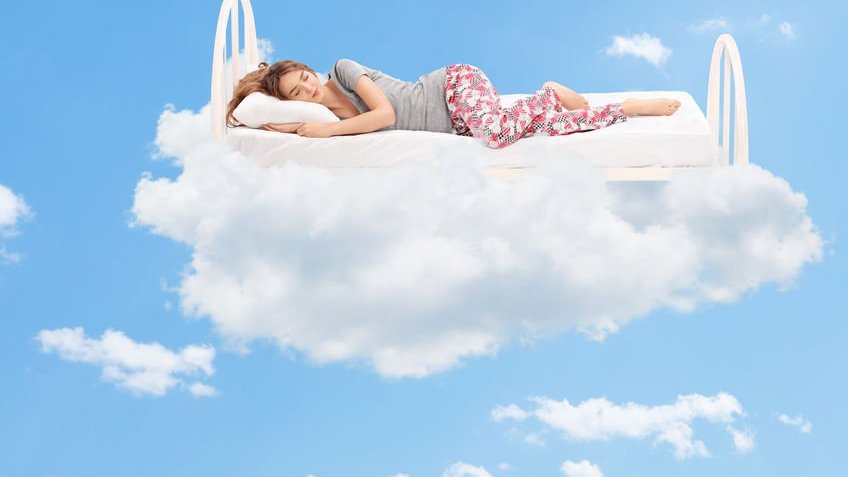 Mulher dormindo em cama nas nuvens