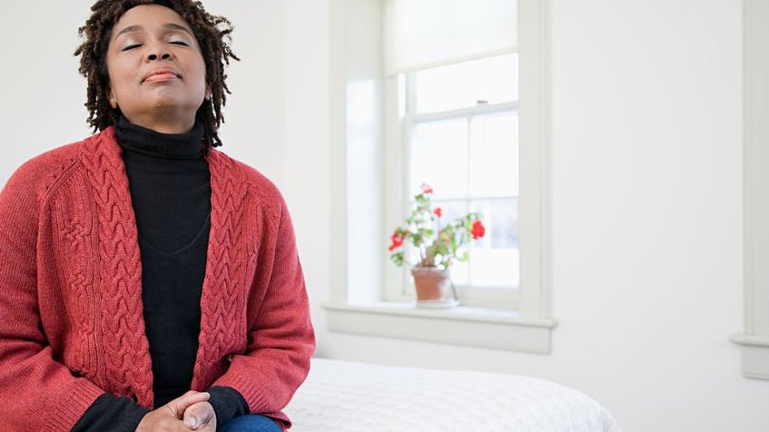 Mulher meditando em casa