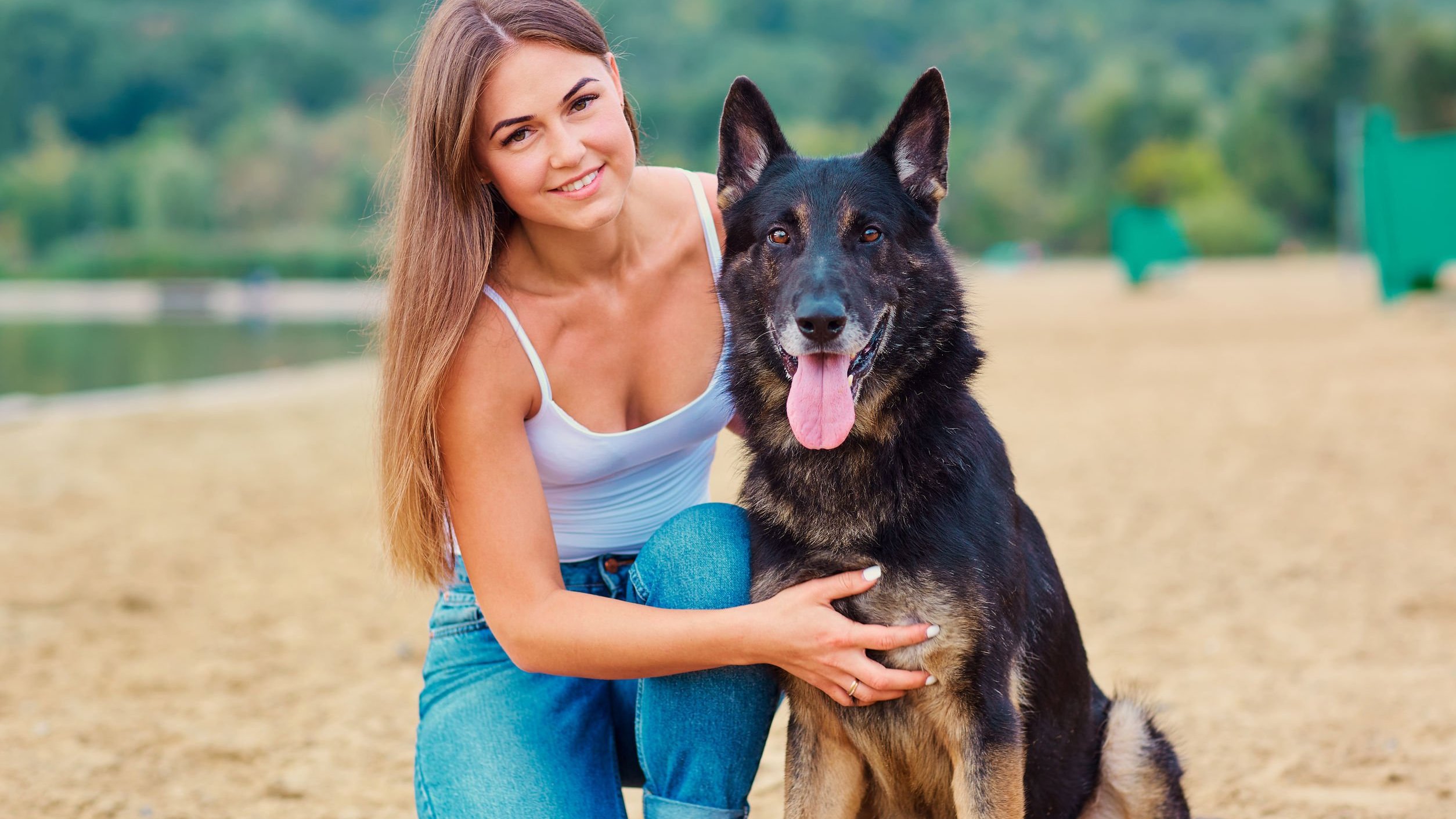 Mulher sorrindo ao lado de cachorro.