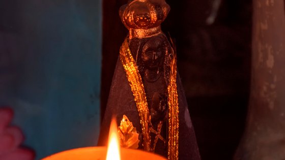 Imagem de Nossa Senhora Aparecida e vela ao lado