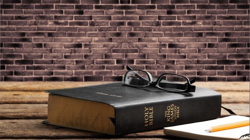 Bíblia com óculos em cima