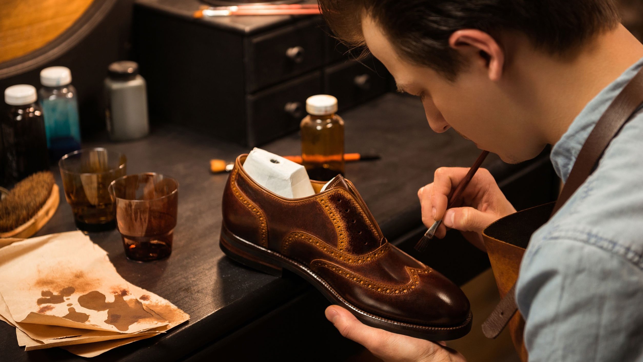 Sapateiro pintando sapato.