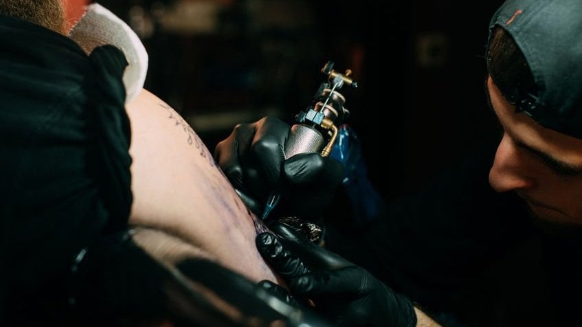 Homem tatuando outra pessoa