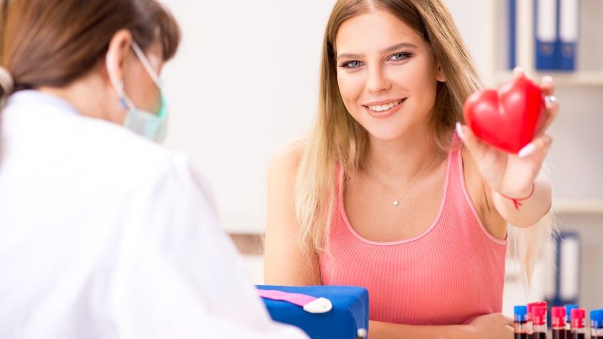 Mulher segurando coração, símbolo da doação de sangue