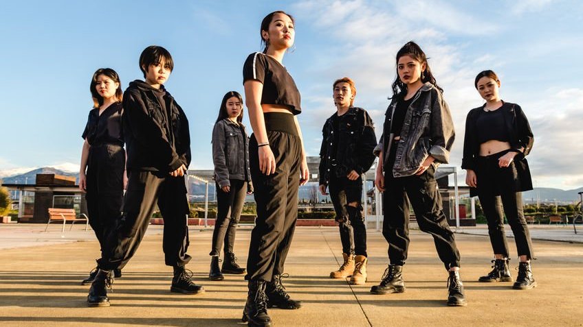 Grupo de K-pop de pé em ambiente aberto