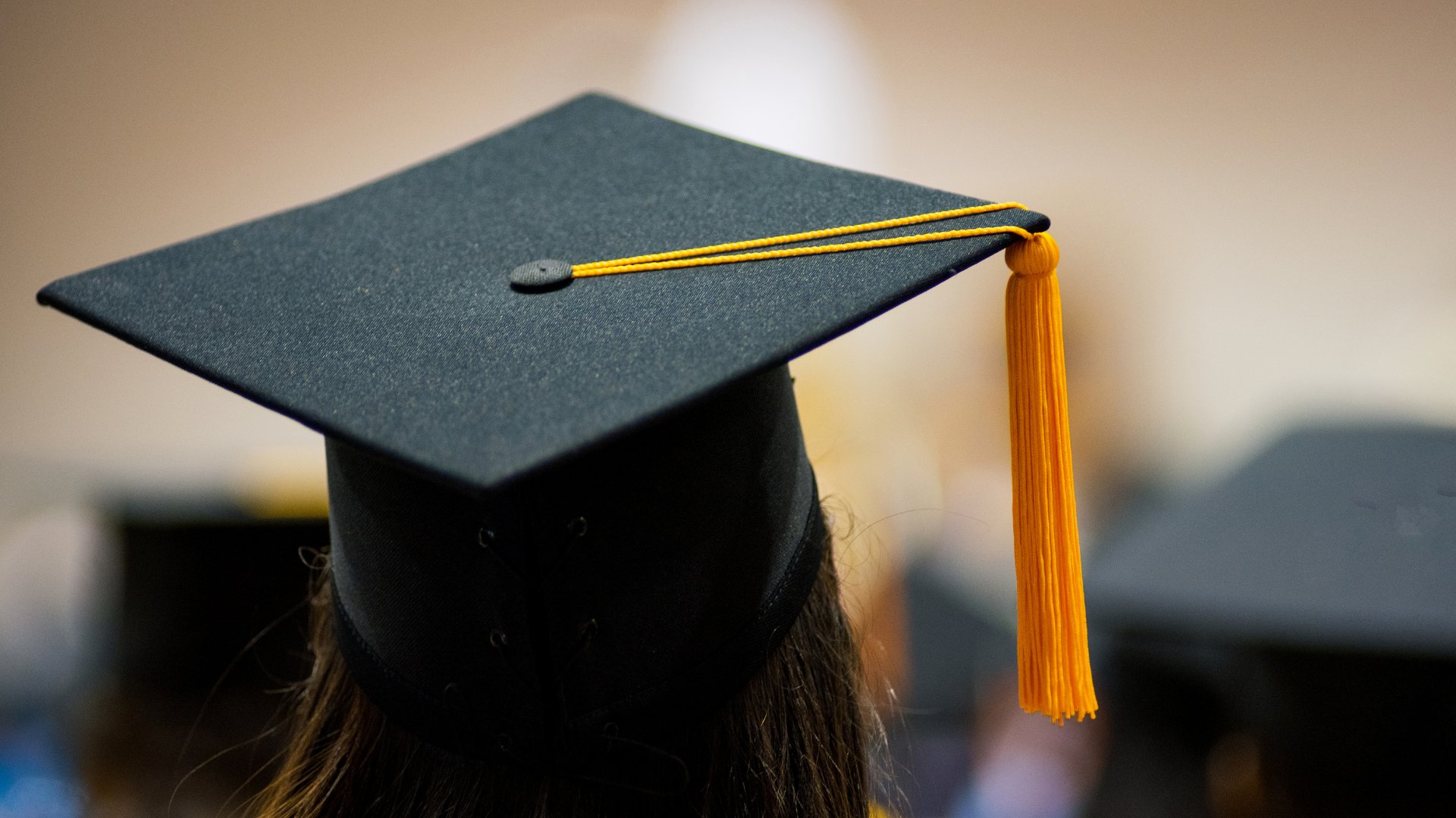 Mulher usando capelo na formatura da pós-graduação