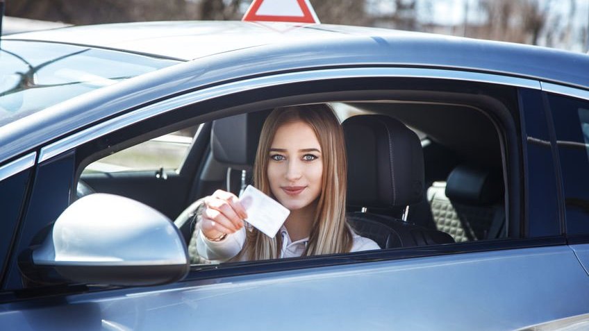 Mulher jovem mostrando carteira de motorista