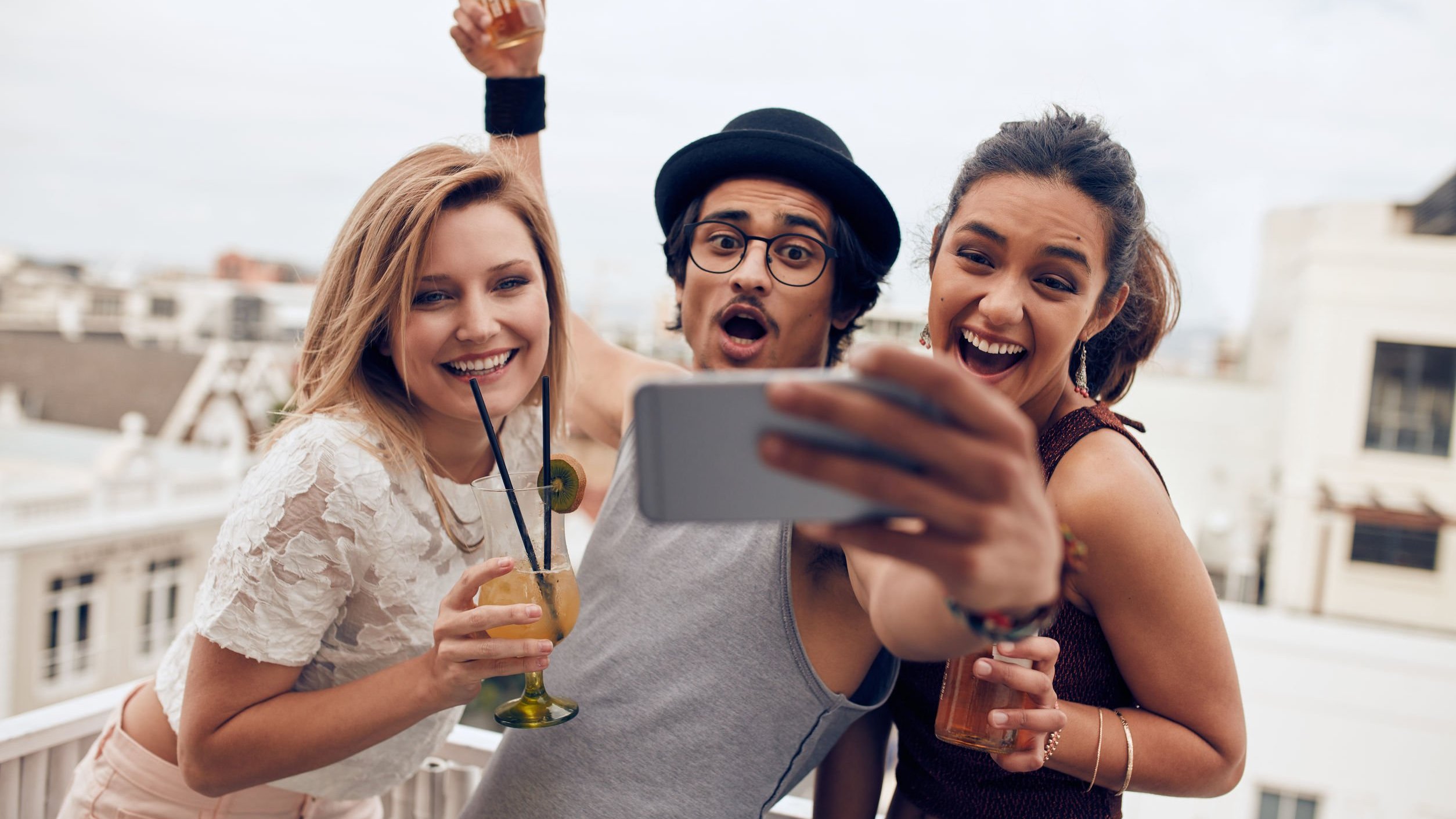 Amigos com expressões sorridentes enquanto tiram foto.