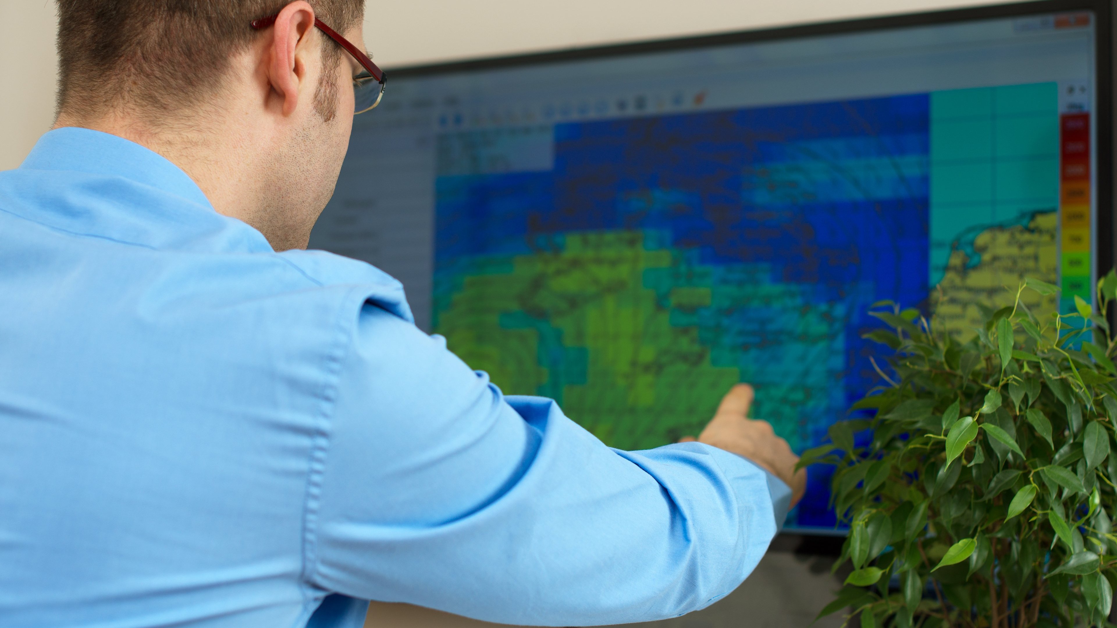 Meteorologista trabalhando em um computador.