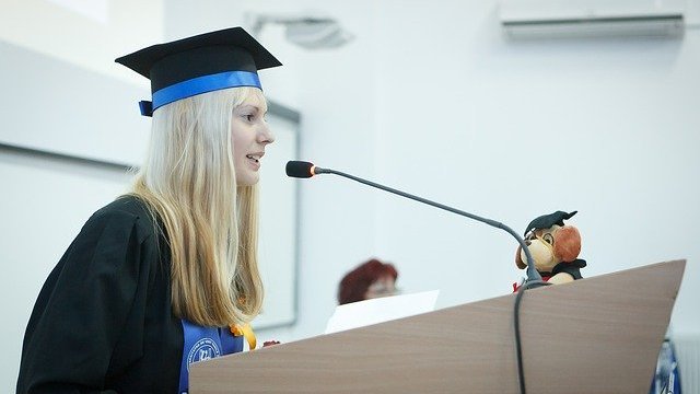 Menina loira fazendo discurso de formatura