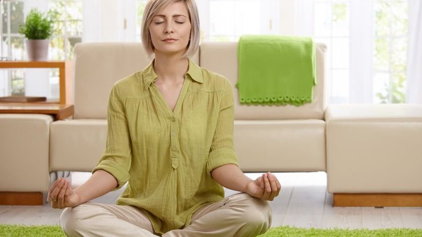 Mulher meditando em sala de estar