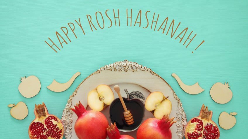 Alimentos típicos do Rosh Hashanah em prato com detalhes dourados