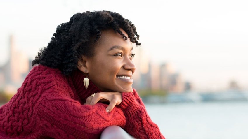 Mulher sorrindo e olhando o horizonte