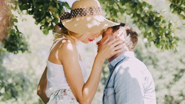 Homem e mulher brancos com os rostos próximos.