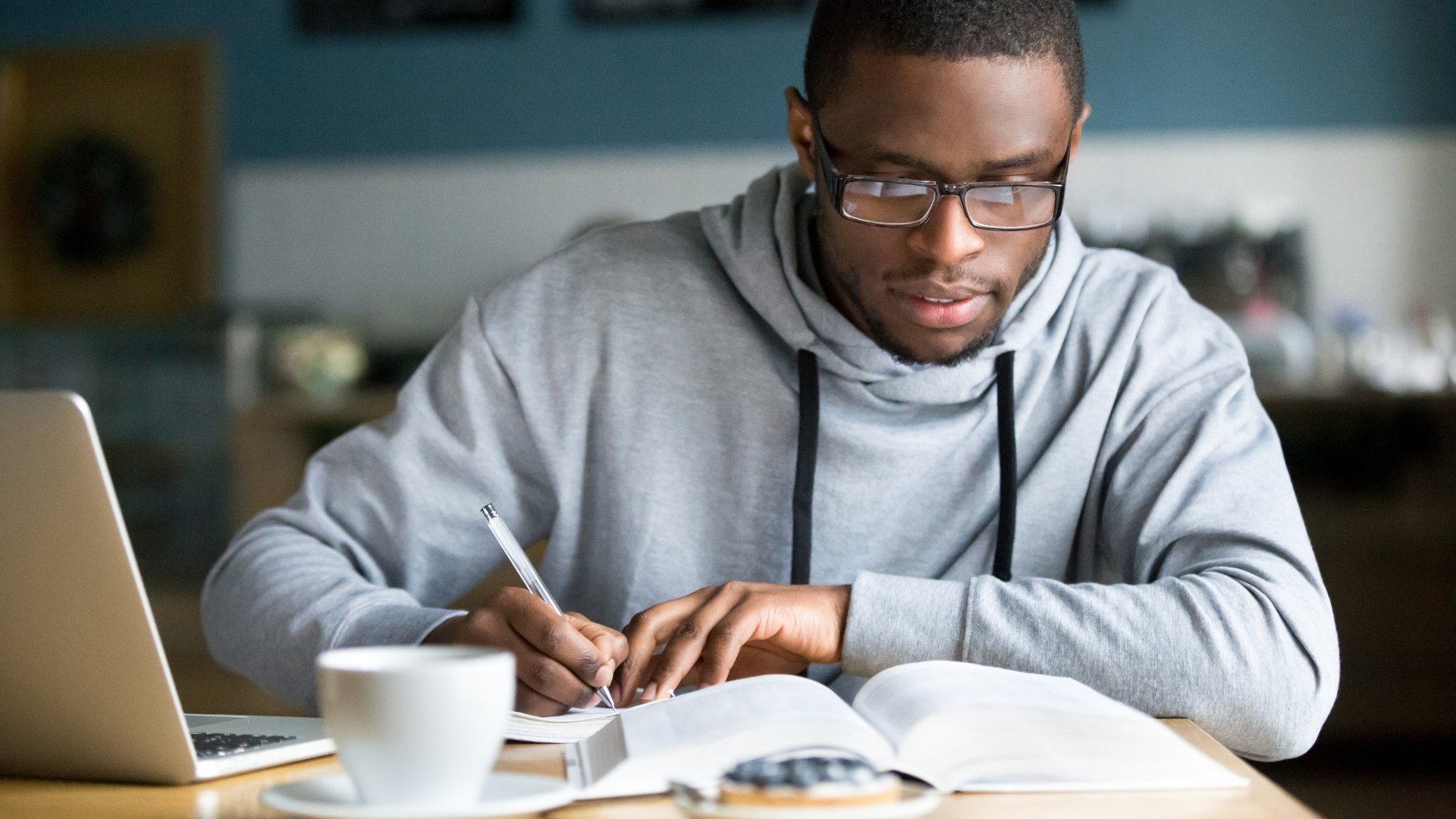 Homem de óculos estudando para o doutorado