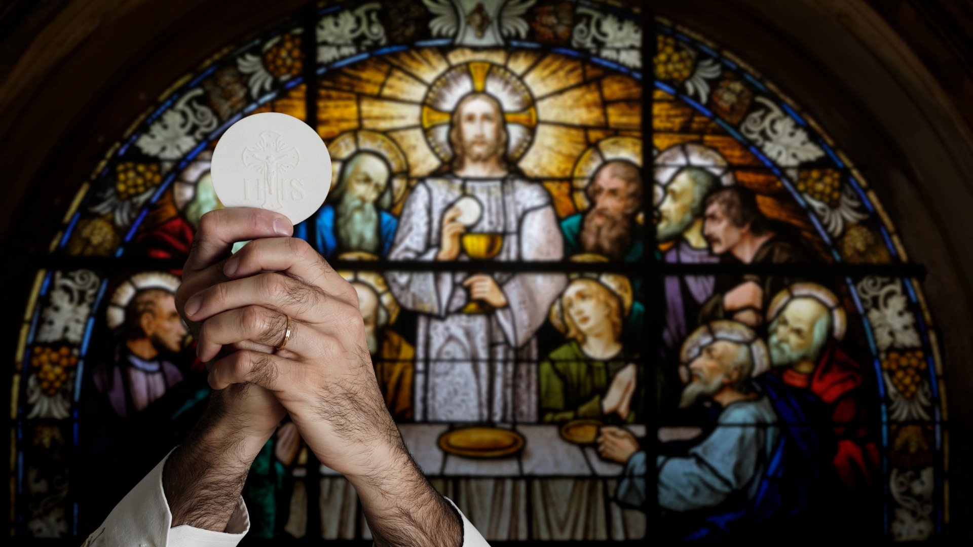 Padre segurando hóstia para cima na igreja