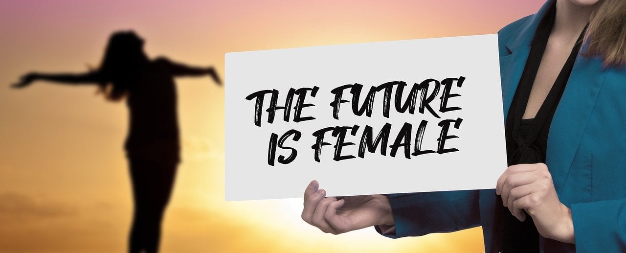Mãos segurando uma placa escrita the future is female.