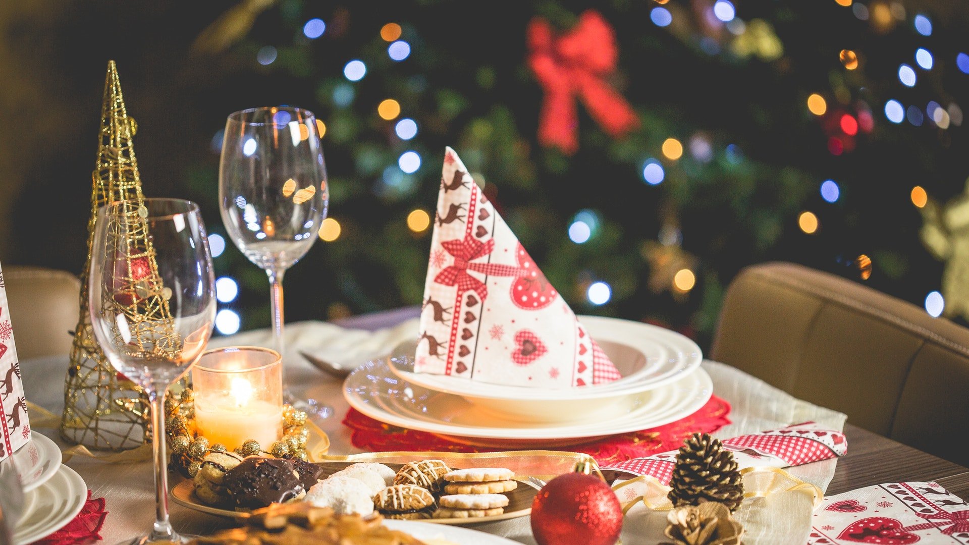 Uma mesa de jantar e, sobrepondo-lhe, alguns adornos natalinos e utensílios de cozinha, como pratos e taças.