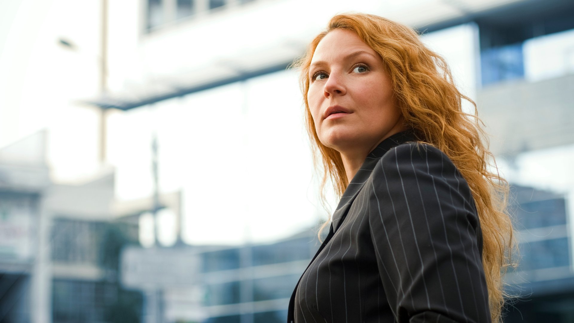 kavardakova_a de Getty Images / Canva / Mensagens Com Amor Uma mulher ruiva de terno. Ela olha pra cima.