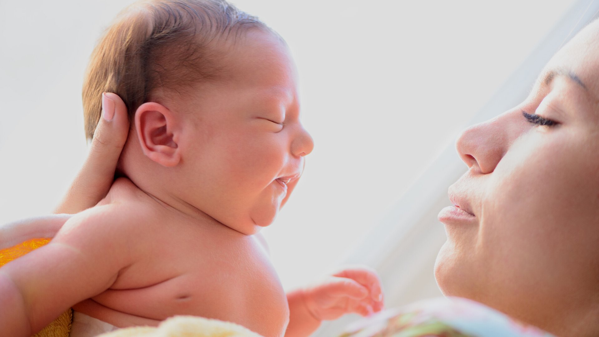 Astakhova de Getty Images Pro / Canva / Mensagens Com Amor Uma mulher segurando um bebê recém-nascido.
