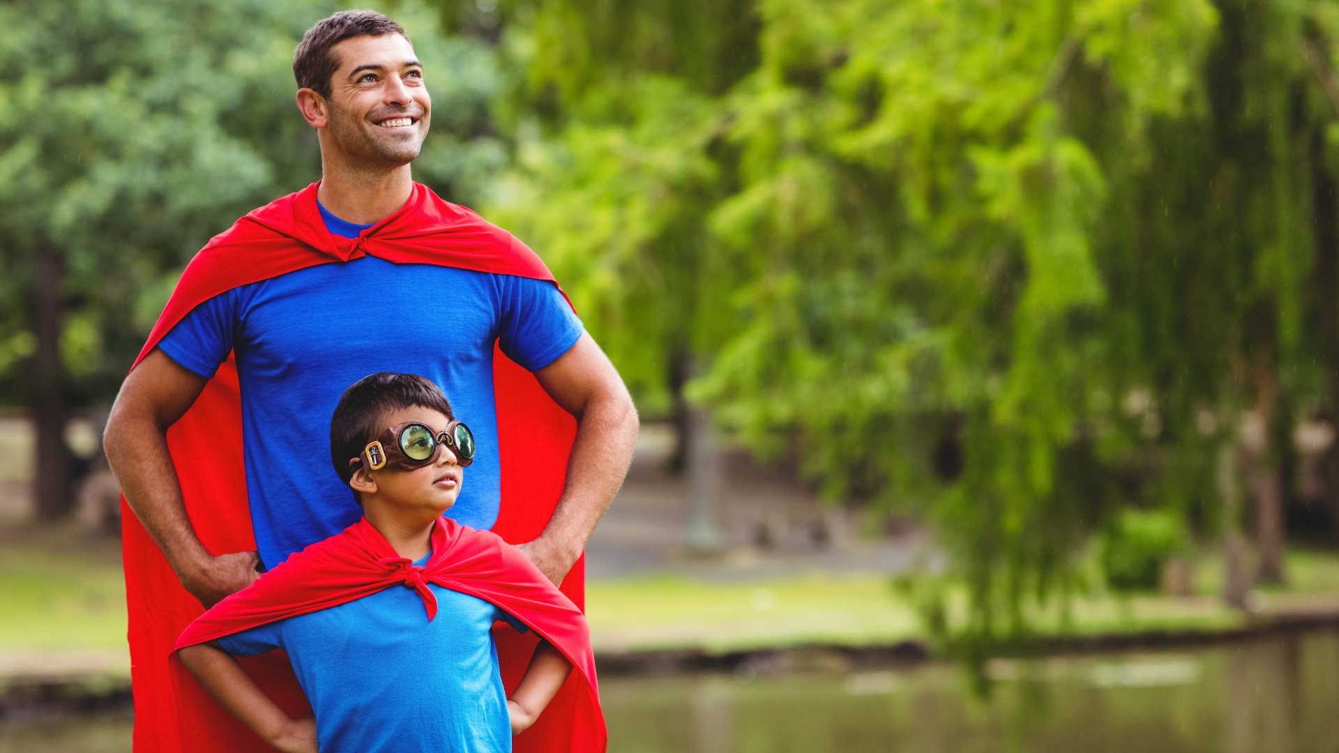 Um homem e um garoto vestidos de super-herói.