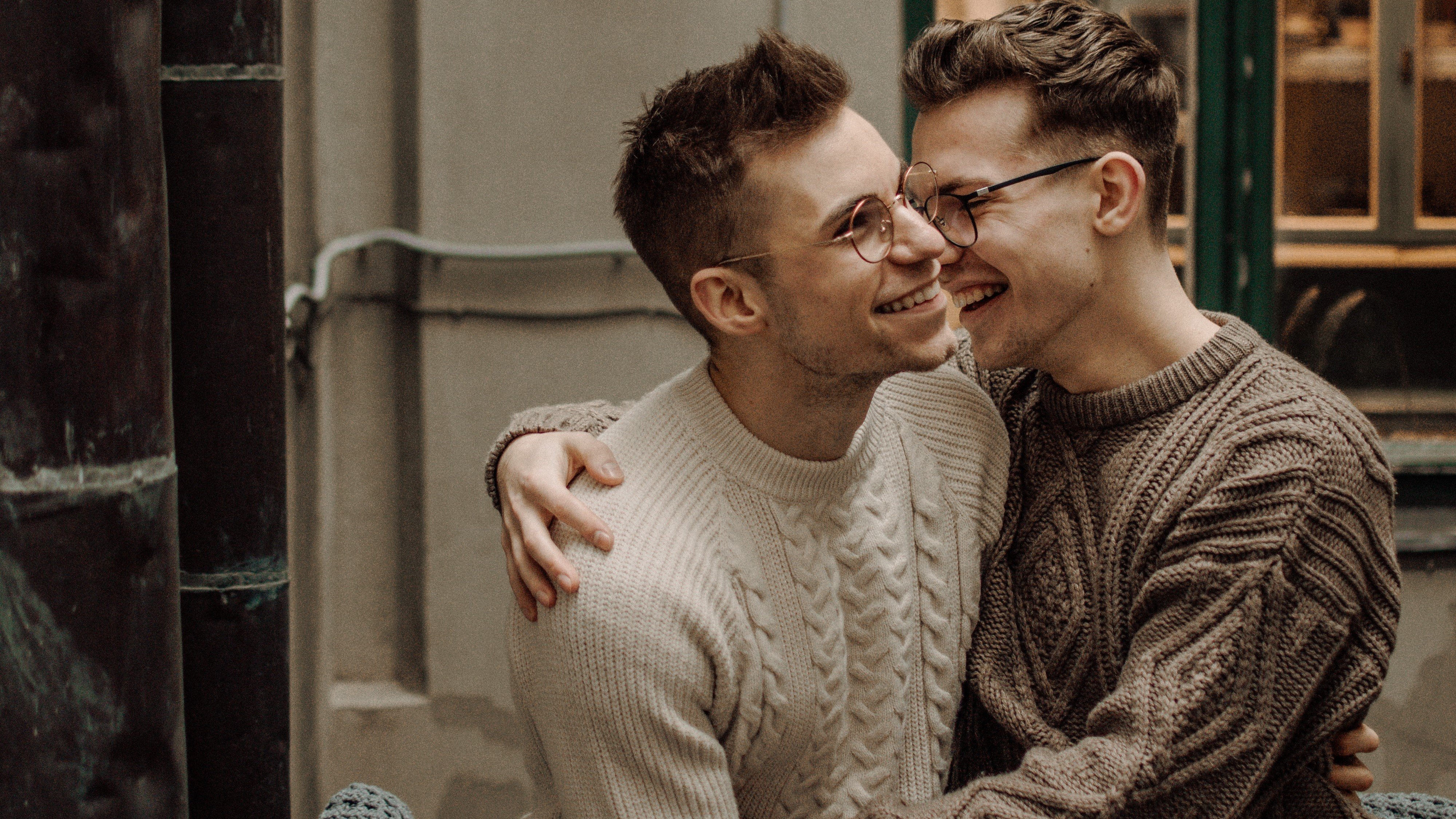 Renate Vanaga/unsplash um casal andando de bicicleta enquanto se olham e juntam as mãos
