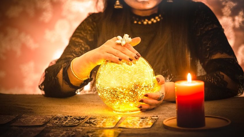 Mulher com as mãos em uma bola de cristal