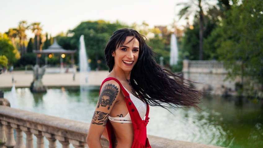 Mulher trans sorrindo para a foto