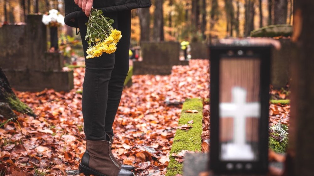 mulher com flores em um cemitério