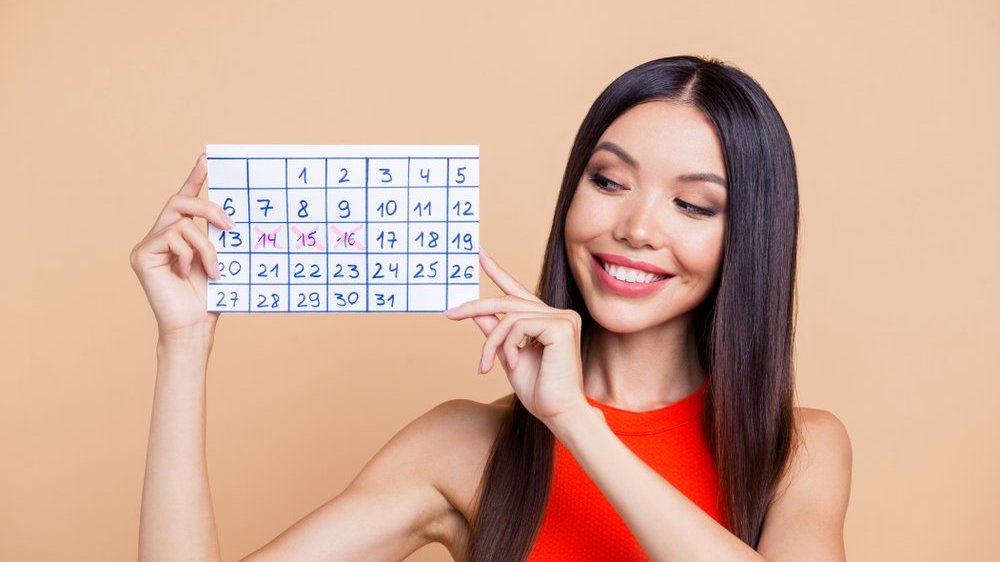 Mulher feliz segurando um calendário