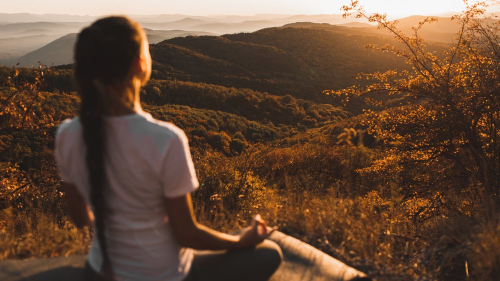 Mulher  meditando em meio a natureza