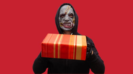 Pessoa fantasiada com máscara de terror entregando um presente