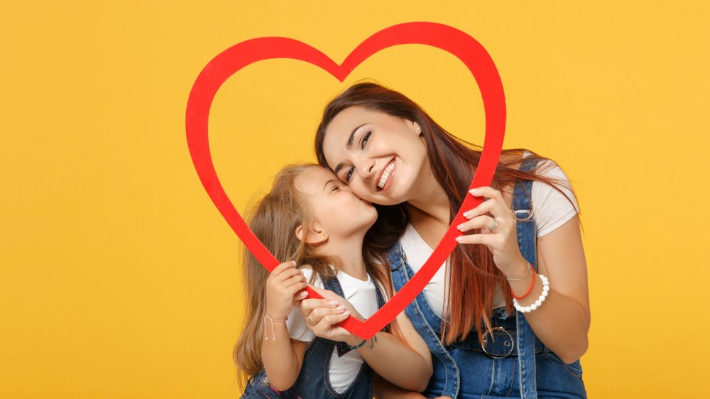 Menina beijando a bochecha da mãe