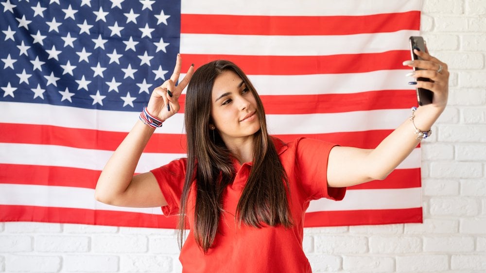 Menina tirando foto com a bandeira americana