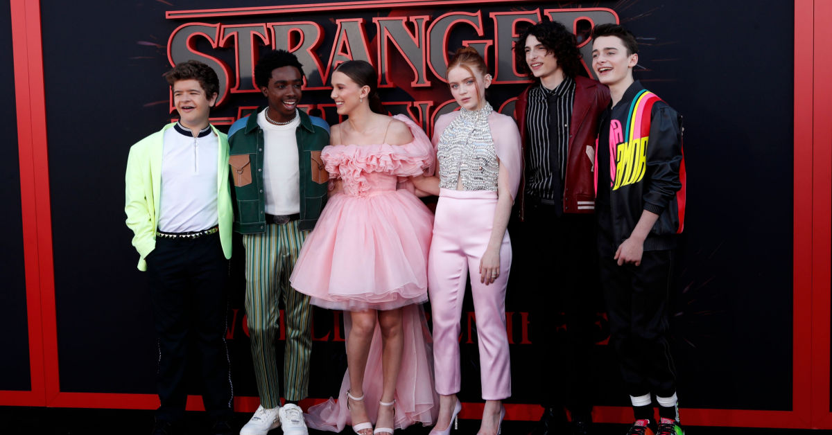 Personagens de Stranger Things posando para foto em evento