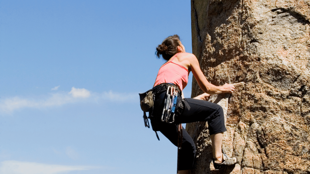 Foto de mulher escalando uma pedra