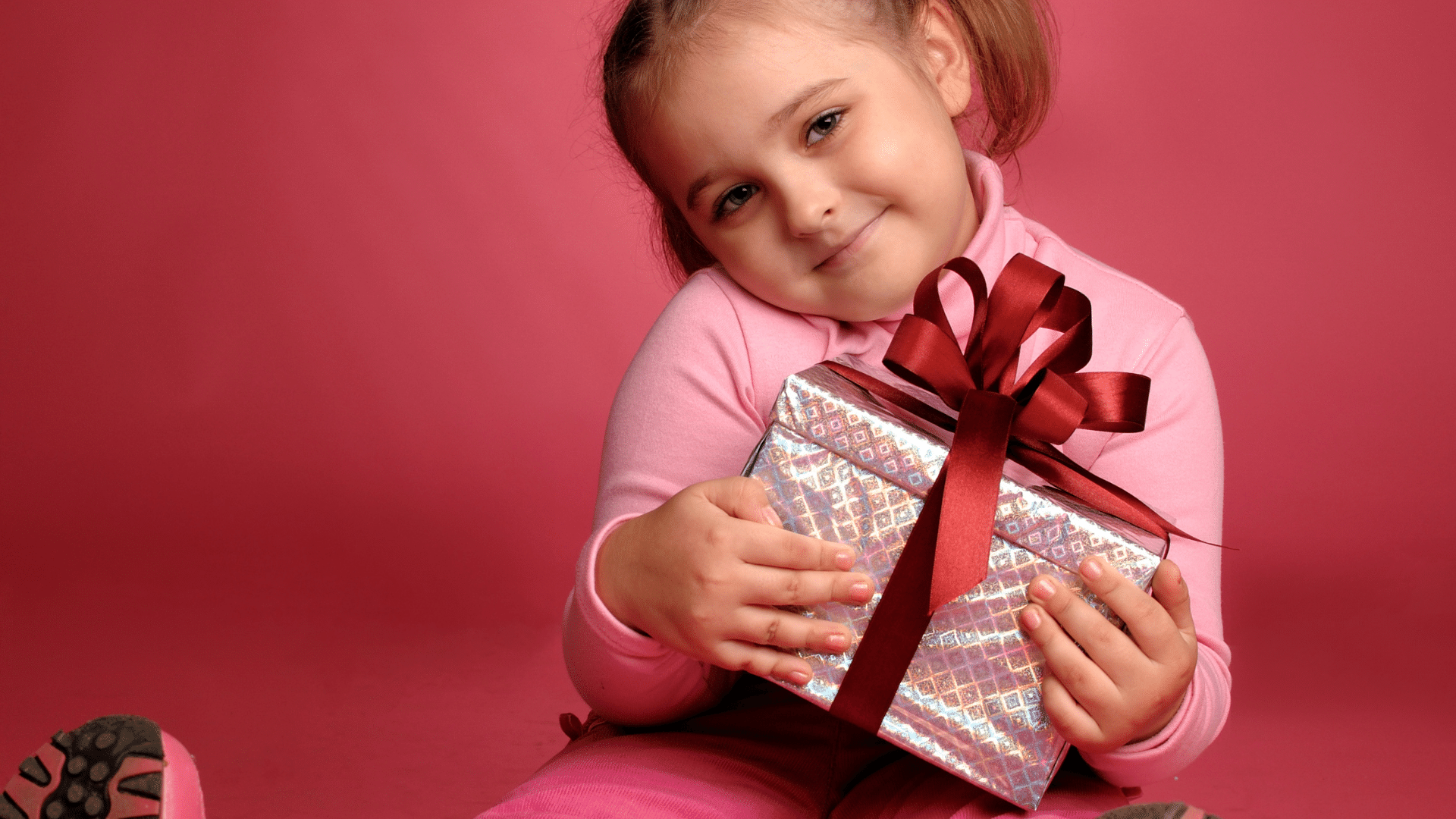 Criança segurando caixa de presente na mão