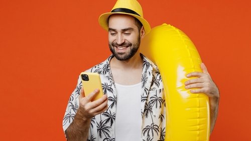 Homem com roupas de praia e uma boia na mão