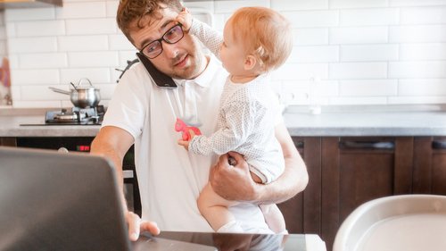 Homem trabalhando com um bebê no colo