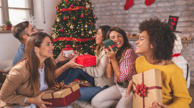 Amigos conferindo os presentes de Natal em um ambiente decorado de forma natalina