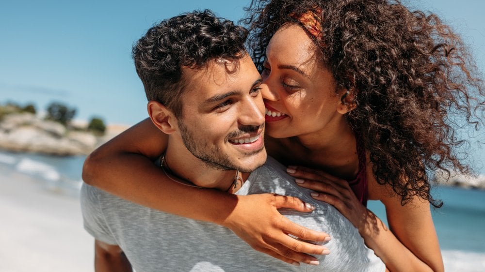 Casal feliz se abraçando e rindo ao ao livre