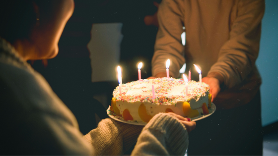 Pessoa segurando bolo de aniversário