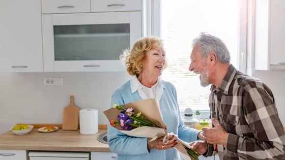 Homem dando um buquê de flores à sua companheira