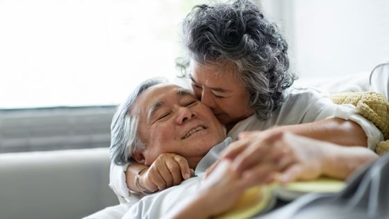 Casal idoso abraçados e sorrindo