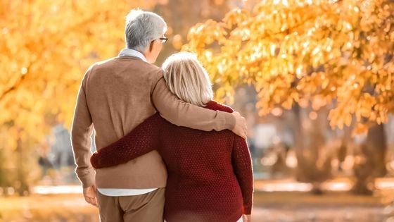 Casal andando abraçados em um parque