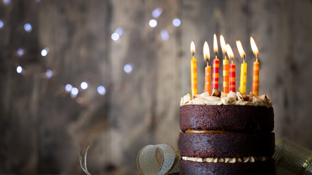 Bolo com várias velas de aniversário em cima