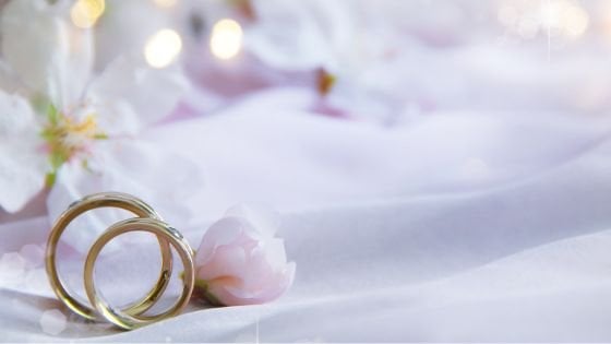 Dois anéis em cima de um lençol com flores