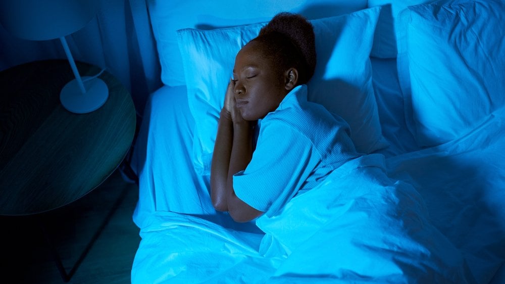 Mulher dormindo tranquilamente em sua cama à noite