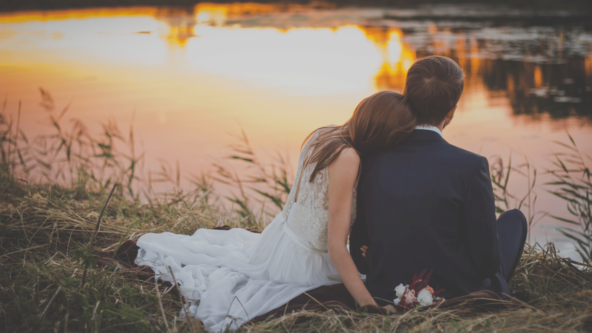 Esposa e marido admirando o lago ao pôr do sol.