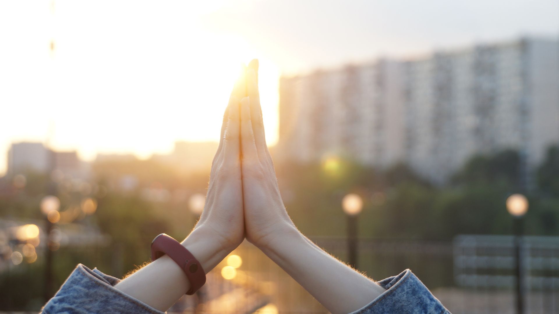 Imagem de mãos femininas juntas e erguidas para o céu em sinal de gratidão